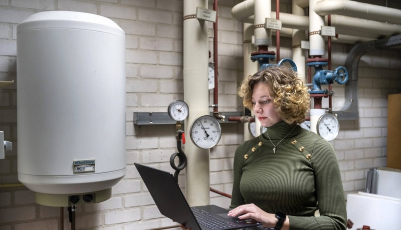 vrouw met laptop in een technische ruimte