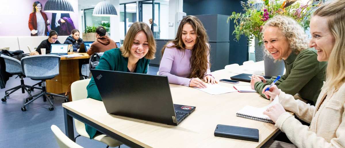 Post-hbo Bedrijfskunde, deelnemers werken samen aan een opdracht met laptop.