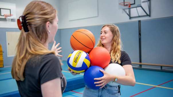 Twee PMT studenten in gymzaal aan de slag met ballen