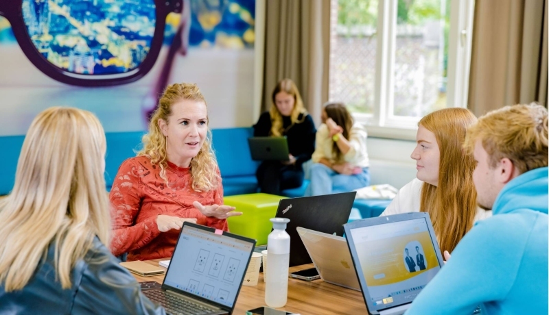 Communicatie studenten en docent aan tafel