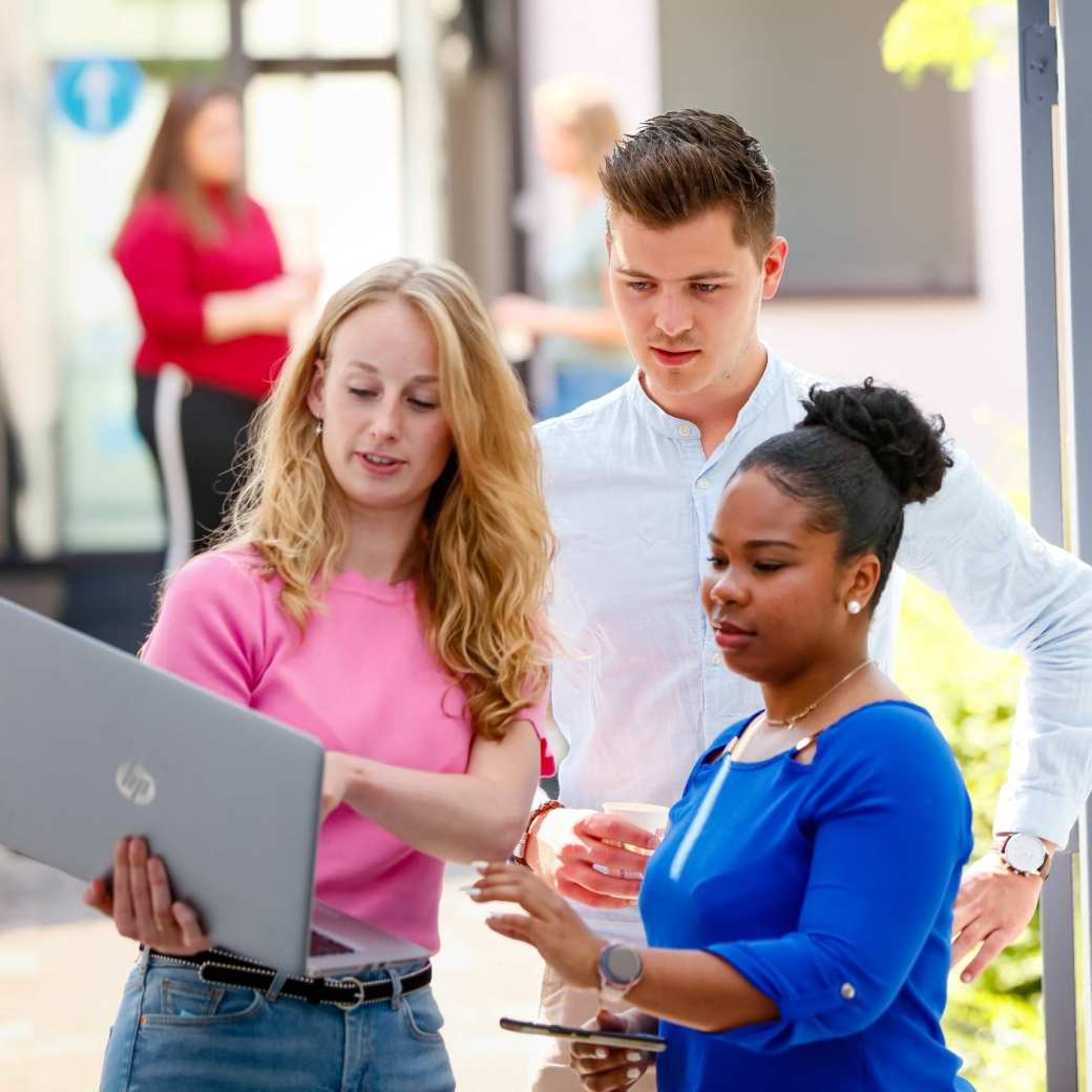Studenten kijken samen naar 1 laptop