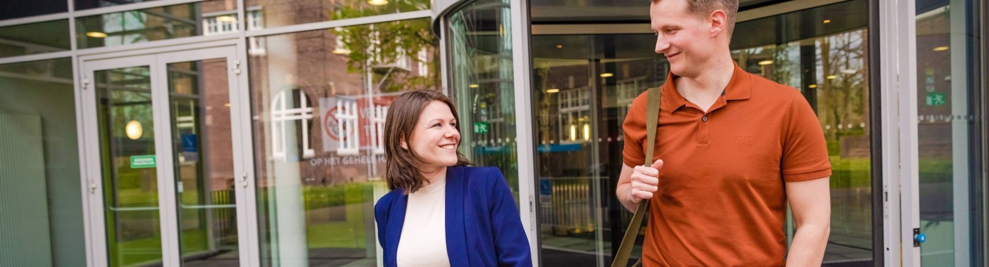 werknemer en arbeidsdeskundige lopen een gebouw uit