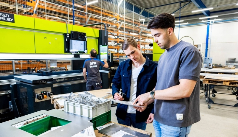 Twee studenten Technische Bedrijfskunde overleggen op de werkvloer van ARA.