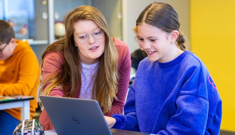 Fotoshoot op het Citadel 2024. De docente kijkt mee op het laptopscherm van een meisje in de klas. 