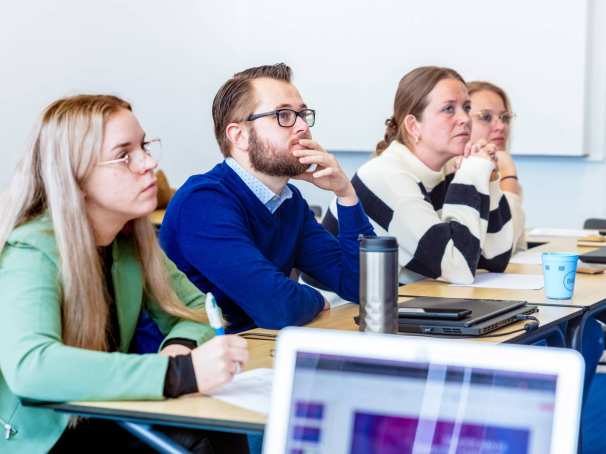 Man en drie vrouwen luisteren naar presentatie. Op de Groenewoudseweg. De opleiding maag-, lever-, darmverpleegkundige.