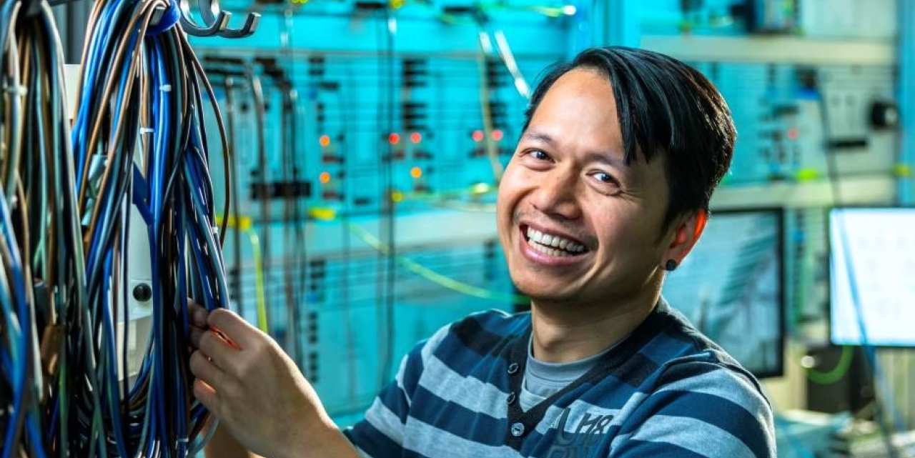 Lachende man sorteert kabels in WATTS simulatieruimte. 