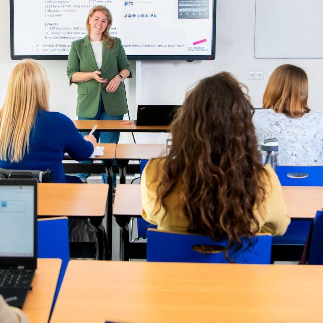 Deelnemers en docenten van de post-hbo Bedrijfskunde in overleg, lachend.