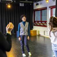 Docent en leerlingen in een theaterruimte