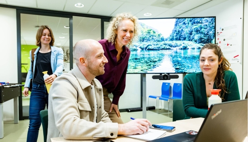 3 deelnemers van de post-hbo Bedrijfskunde werken samen aan een opdracht met hun laptops