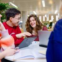Studenten werken samen achter een laptop
