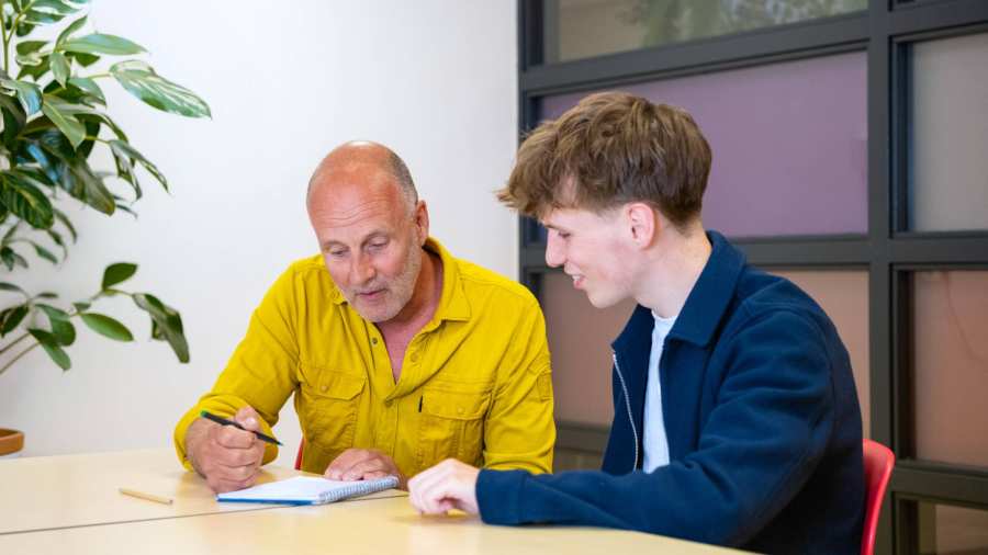 student ergotherapie zit achter laptop en is in gesprek