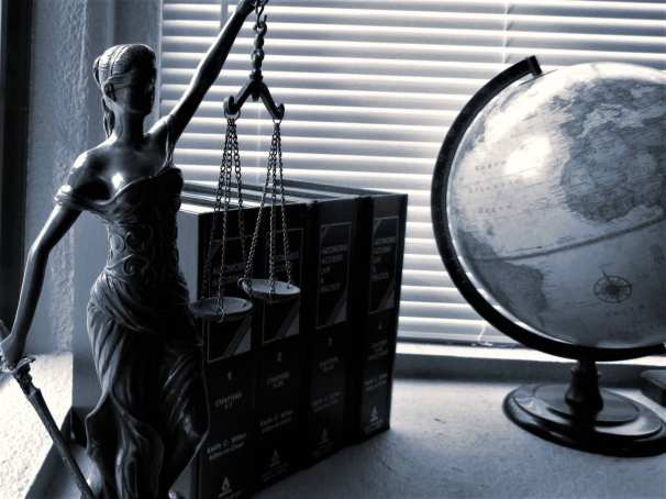 Vrouwe justitia met wettenbundels en wereldbol