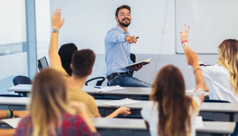 onderwijs en opvoeding, leerlingen steken hand op, docent wijst leerling aan