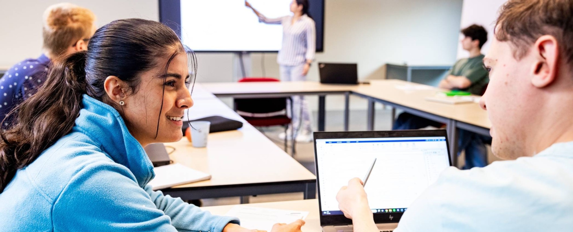 Studenten overleggen in de klas om een wiskundige berekening te maken