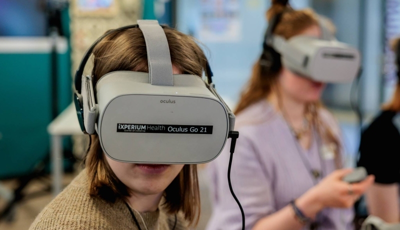 Twee vrouwen met een grijze virutal reality bril op van ixperium health