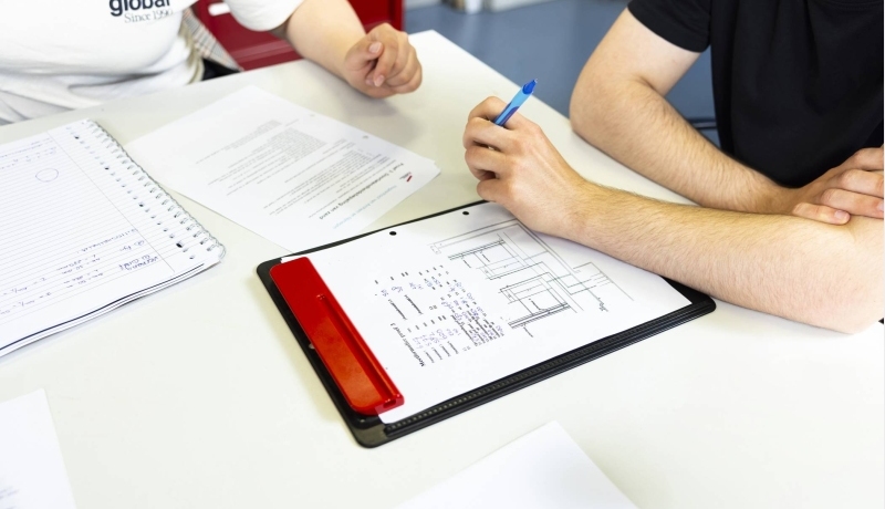 student maakt aantekeningen op een schrijfbloc