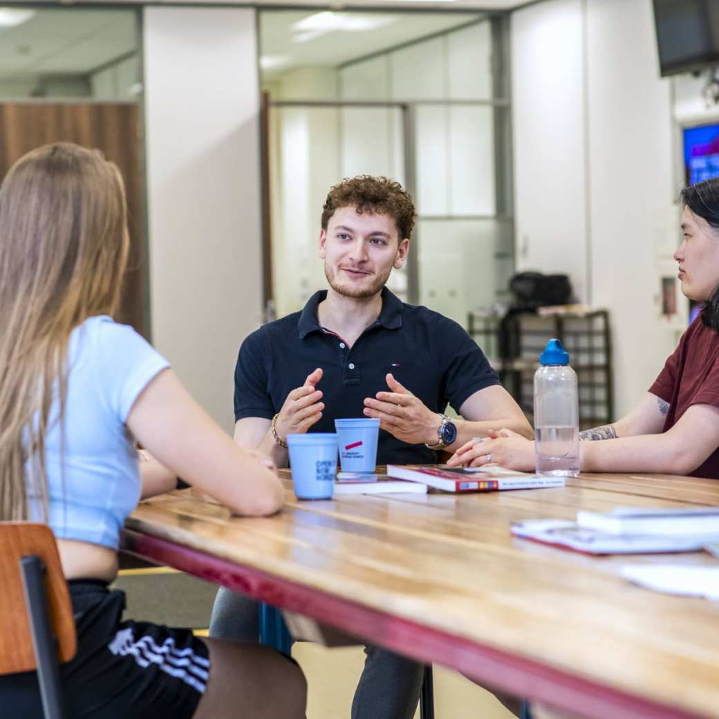 ALO studenten kletsen met elkaar aan tafel op het Gymnasion