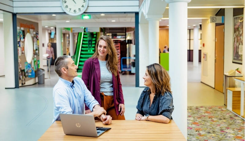 Starten met je deeltijdstudie: 3 studenten werken in de hal.