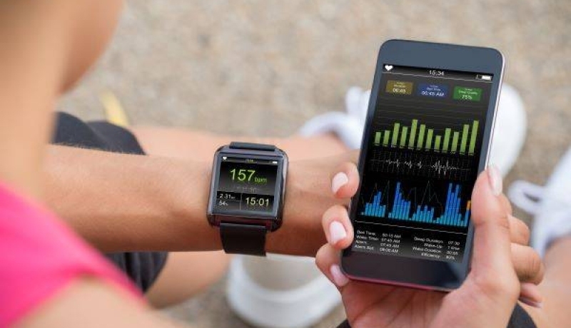 Vrouw met mobiele telefoon aangesloten op een smartwatch- datagedragen fysiotherapie