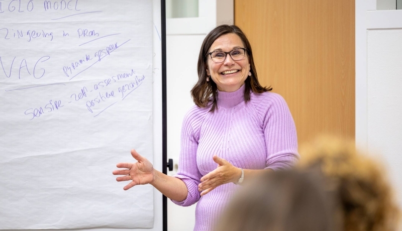 Ruth Pel staat voor een groep en vertelt over het lectoraat Wijkverpleging.