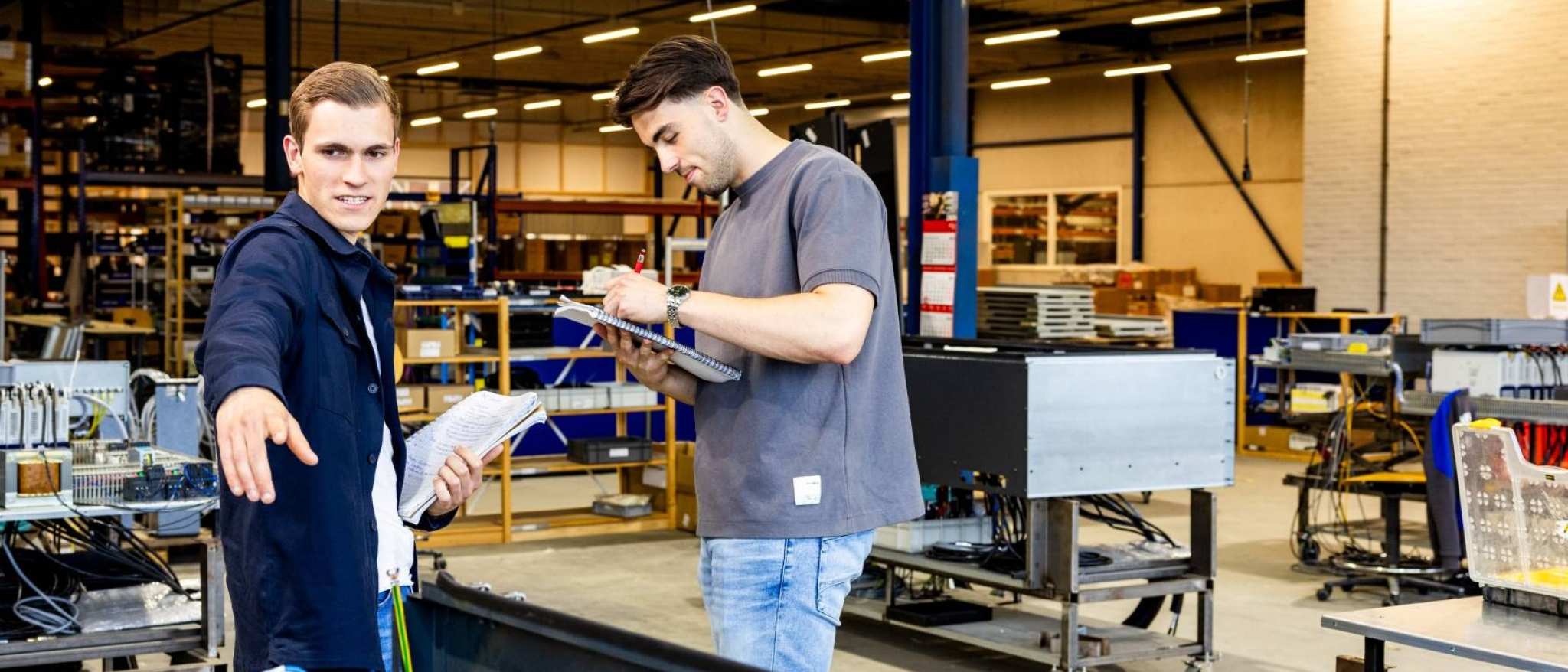 Technische Bedrijfskunde studenten werken samen op werkvloer.