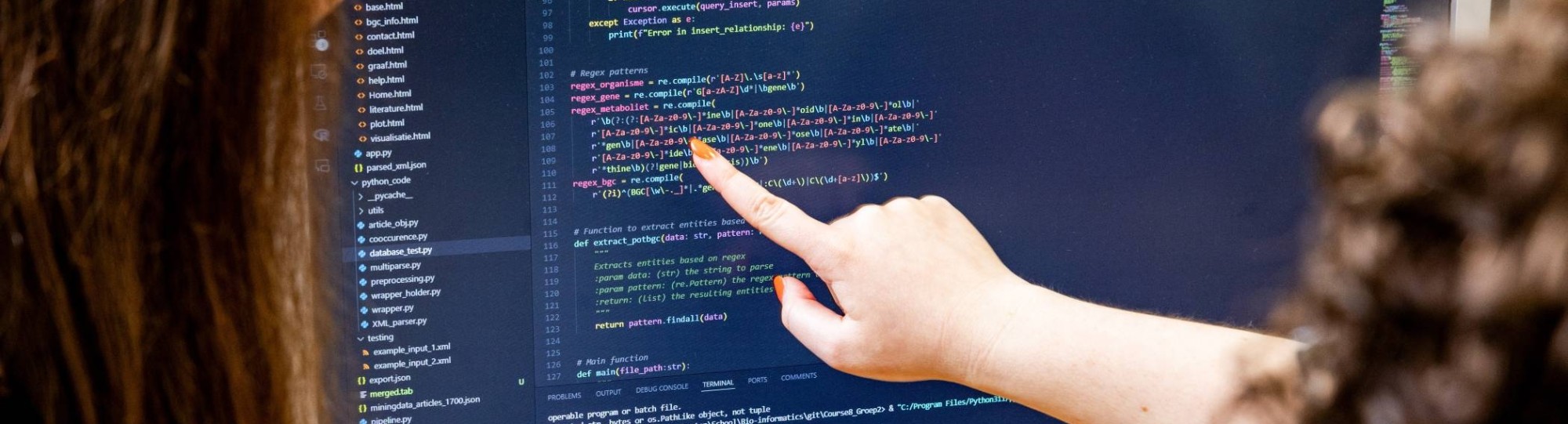 Studenten kijken samen naar coderen op de computer