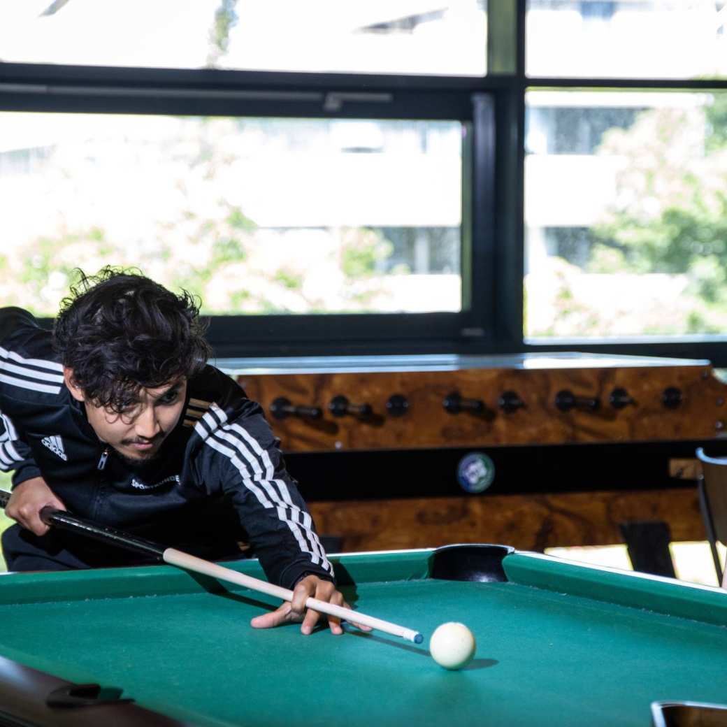 Studenten spelen samen aan de pooltafel