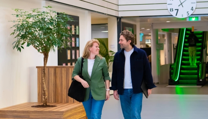 Twee deelnemers van Projectmanagementondersteuning tijdens de pauze wandelend door de gang
