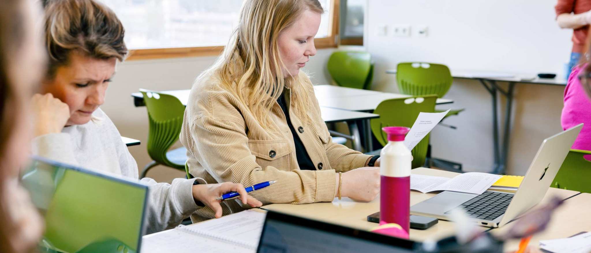 Student leest een blaadje. 