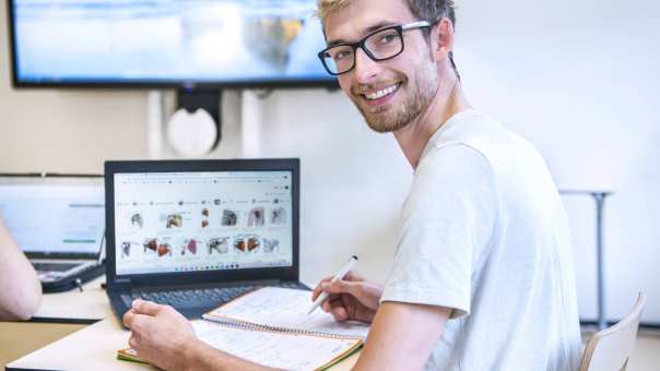 Student MHV tijdens theorieles achter laptop