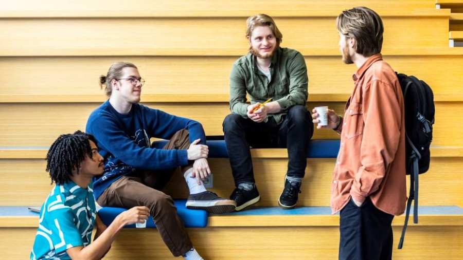 docent Vyasa groet CMD-studenten op de trap in de centrale hal