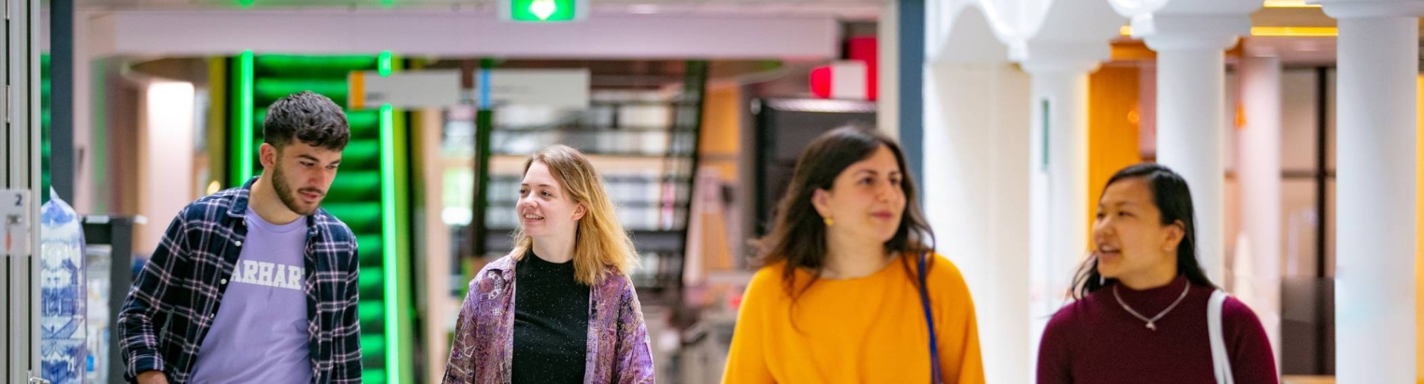 4 studenten Ad Sociaal Financiële Dienstverlening lopen door de hal.