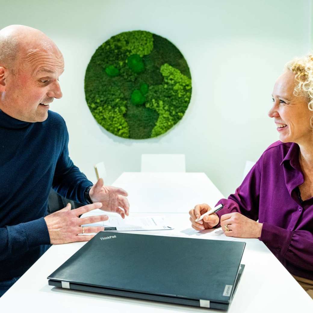 Docent en een deelnemer van de post-hbo Bedrijfskunde hebben een overleg, adviesgesprek