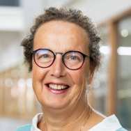 Portretfoto Marian de van der Schueren, brildragend, witte blouse, zeegroene trui