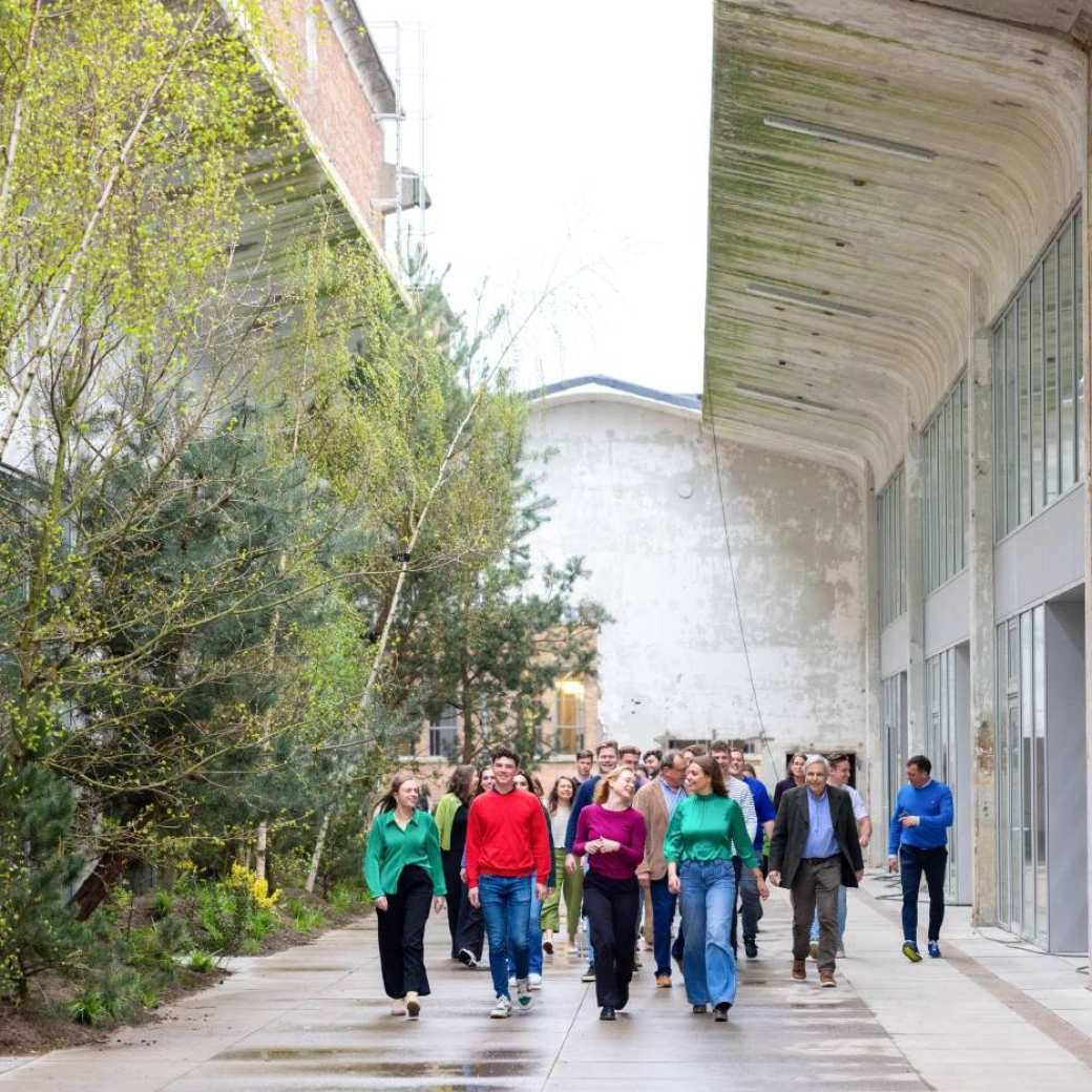 Groep studenten en docenten wandelt door IPKW met groen op de achtergrond. Fotografie Master Circulaire Economie voltijd.