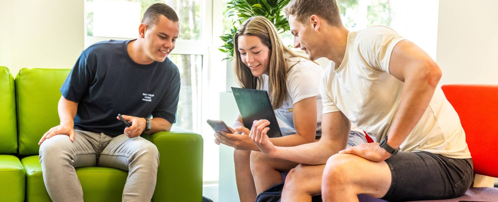 3 cursisten kijken op hun smartphone naar een short video.