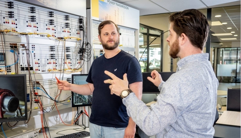 Master Engineering Systems Sustainable Energy student krijgt uitleg van een docent bij de Lucas Nulle panelen.