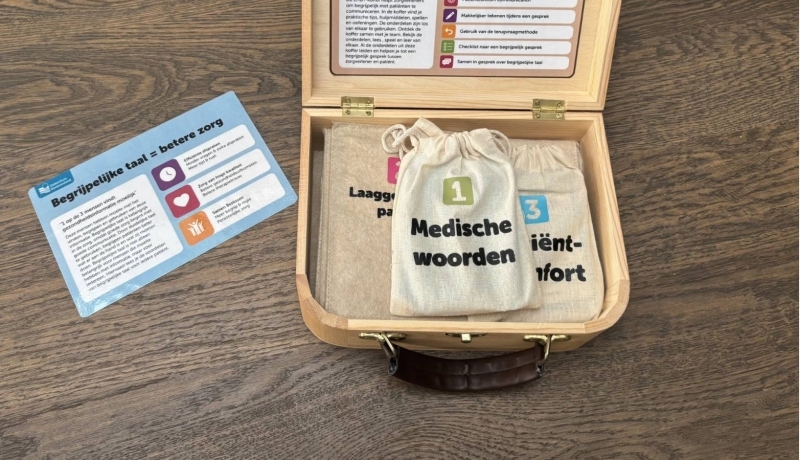 Mirte van Doorn bij de door haar ontwikkelde Taalkoffer, met spellen en tools voor zorgverleners om hen te oefenen met begrijpelijke taal met cliënten te communiceren.
