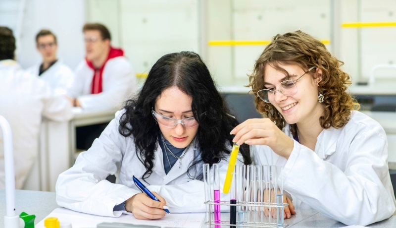 Twee studenten Leraar Natuurkunde kijken aandachtig naar hun experiment.