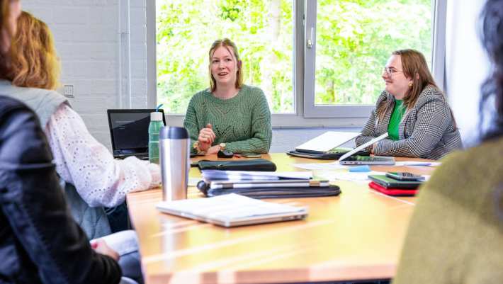 Vrouw in groene trui is in gesprek. Locatie groenewoudseweg, opleding maag-, darm-, leververpleegkundige.