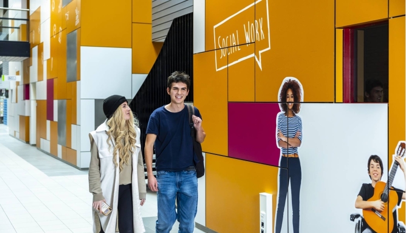 2 studenten International Social Work lopen door de gang van de HAN, Kapittelweg 33.