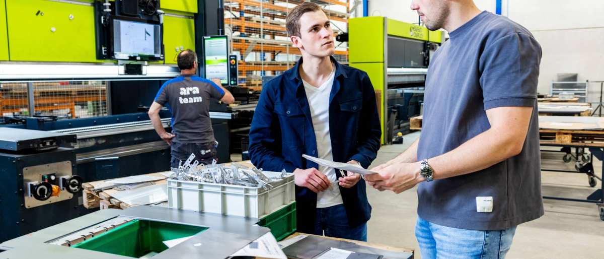 De Technische Bedrijfskunde studenten Derk en Jort overleggen op de werkvloer van ARA.
