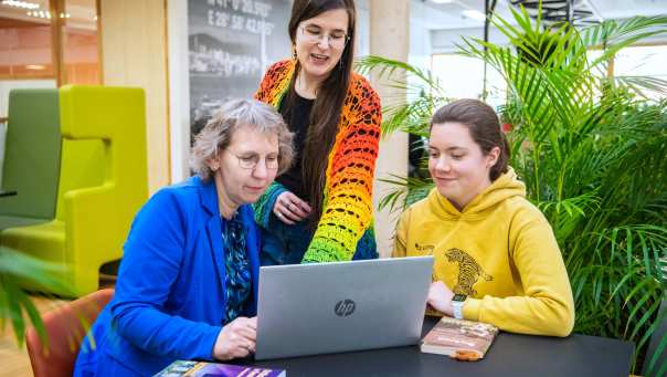 Foto Master Academie Educatie. 3 masterstudenten werken samen en kijken op een laptop. 