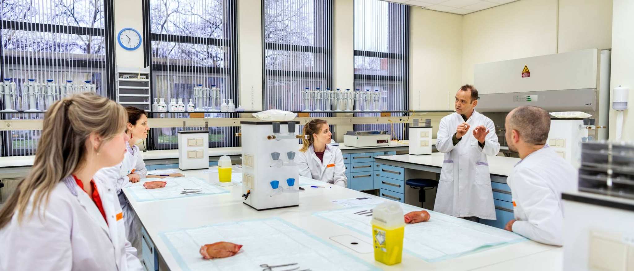 Masterstudenten van de opleiding tot Physician Assistant luisteren naar een docent die instructies geeft over hechten