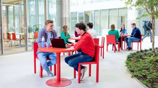Locatieshot van IPKW met drie groepjes studenten aan tafel. Master Circulaire Economie 2024.