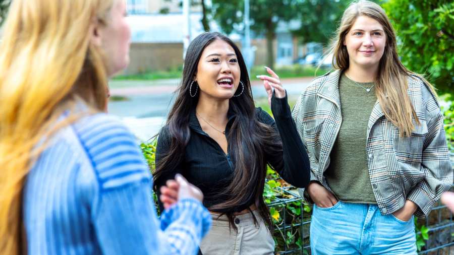 Een groep studenten HAN Social Work zijn samen buiten in gesprek. 
