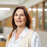 Portretfoto van Harriet Onderstal, witte blouse met cremekleurig vest erover