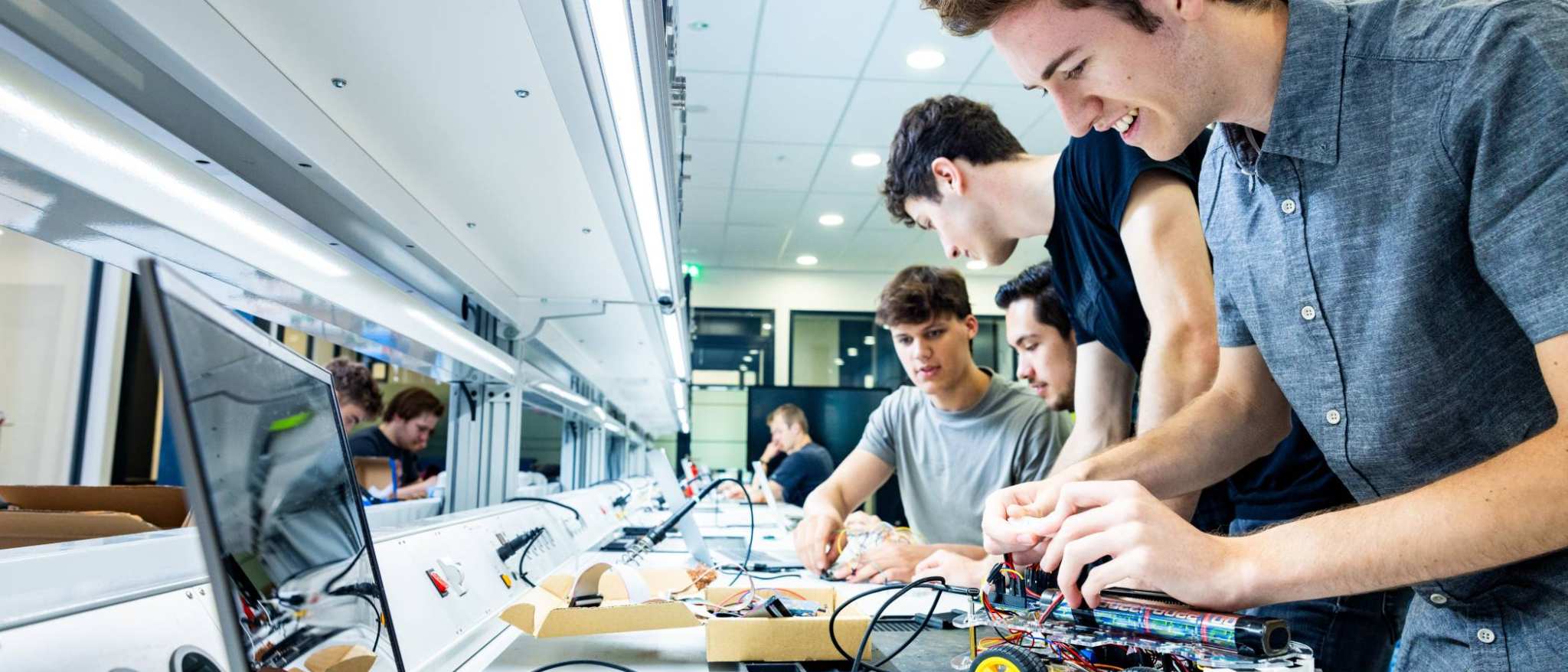 Student Marlo van embedded systems engineering werkt aan een programmeerbare auto in het lab.