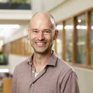 Portretfoto Joost Seeger, rode gemeleerde blouse dragens