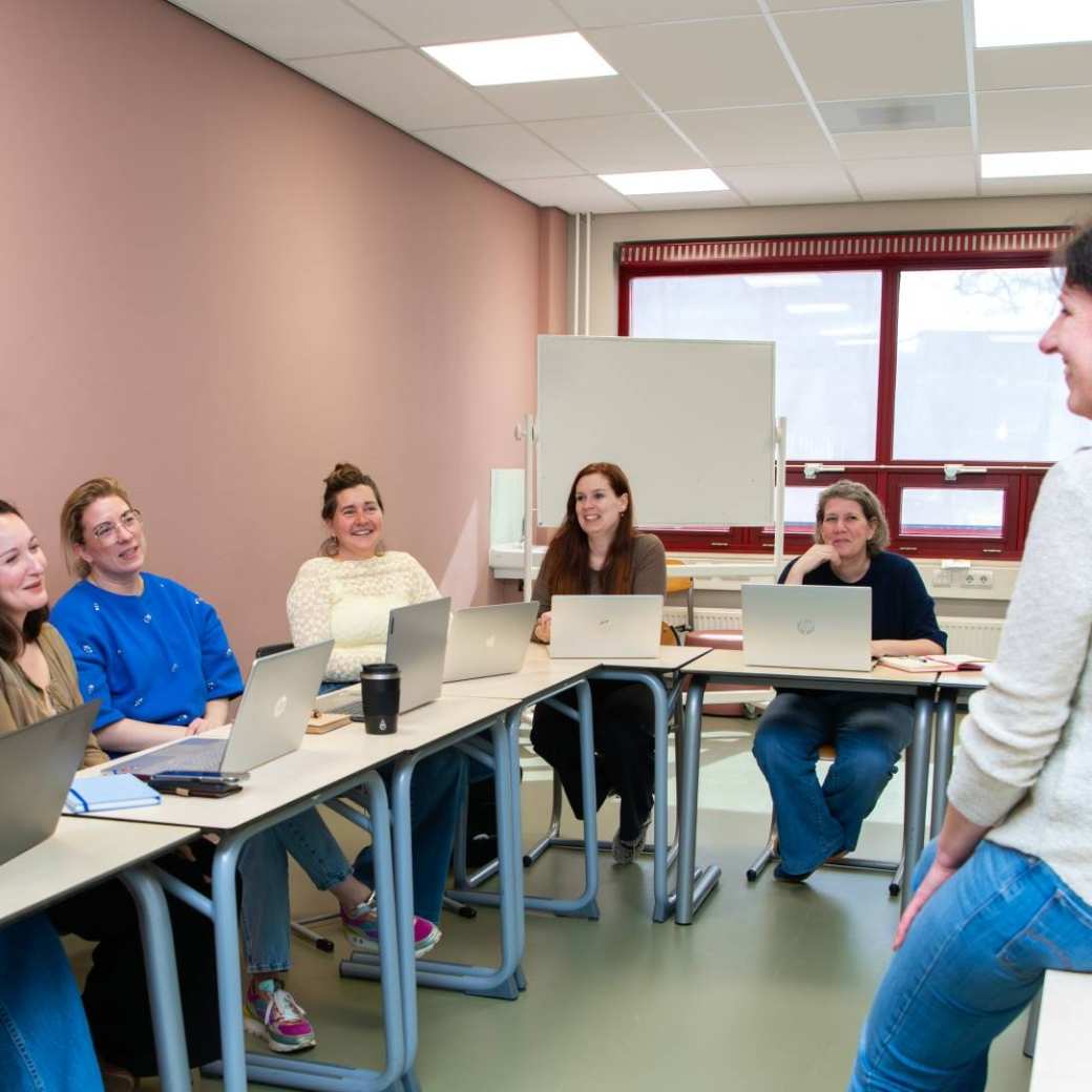 Docent geeft les aan masterstudenten in een klaslokaal.